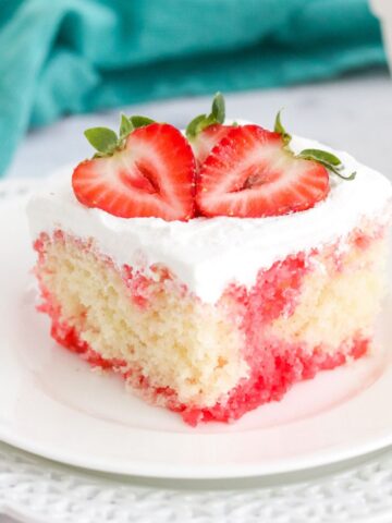 strawberry poke cake slice on a white plate.