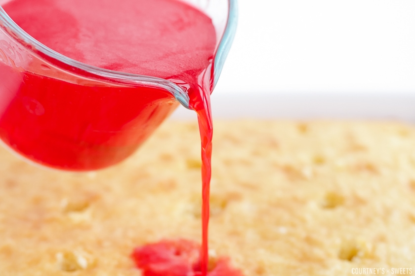 pouring liquid jello over cake.