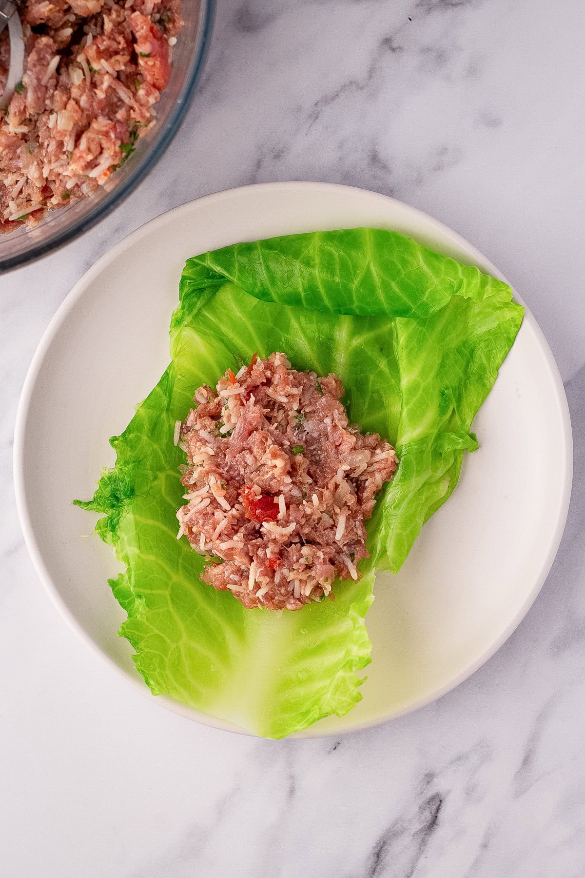 stuffing cabbage leaf with meat mixture.