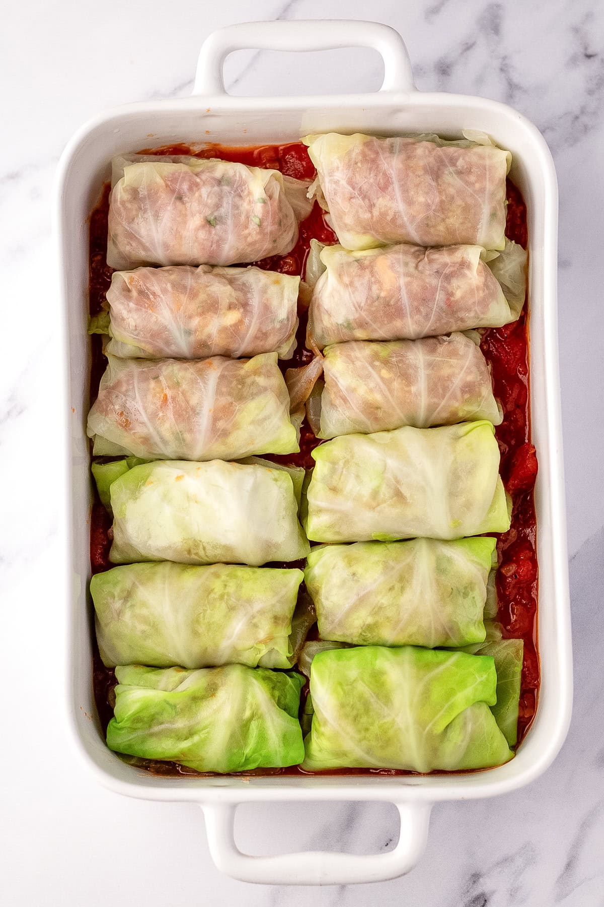 raw stuffed cabbage rolls in casserole dish,