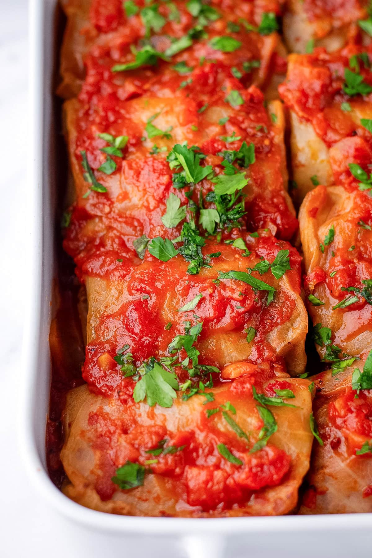 close up of stuffed cabbage rolls in casserole dish.