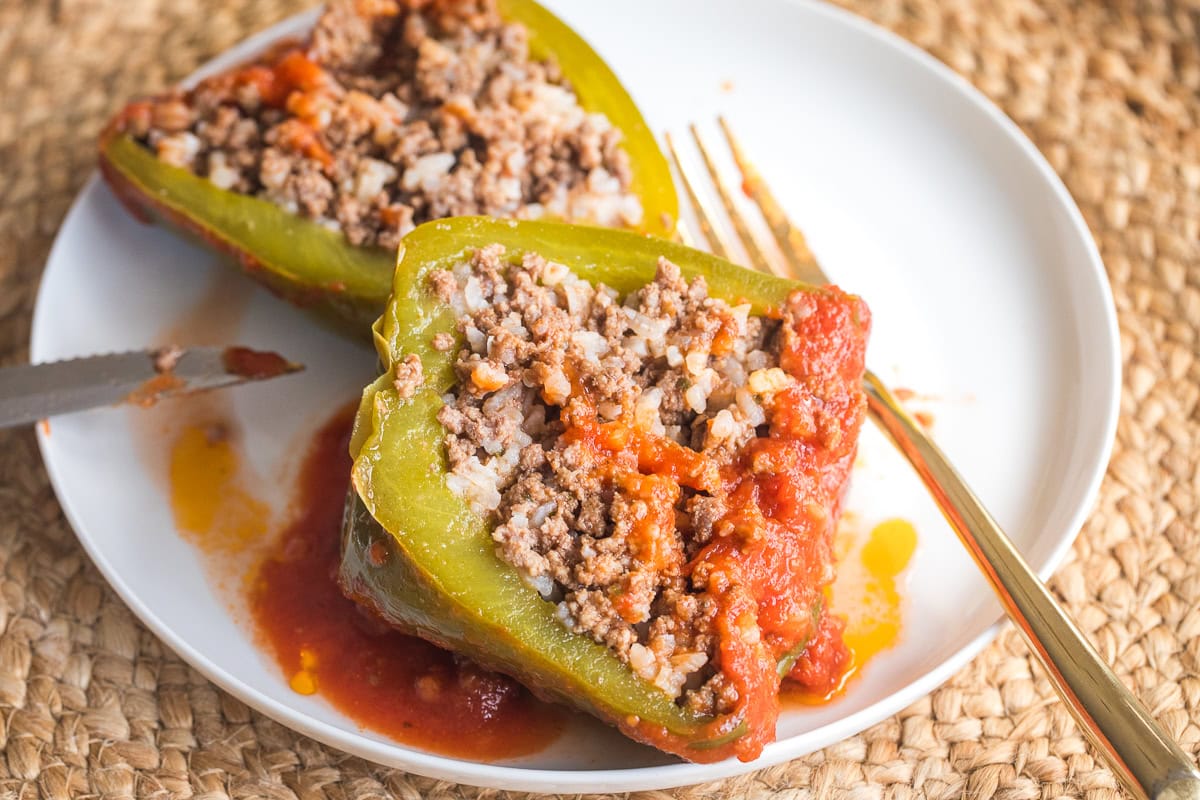 stuffed peppers on a plate cut open to show the stuffing.