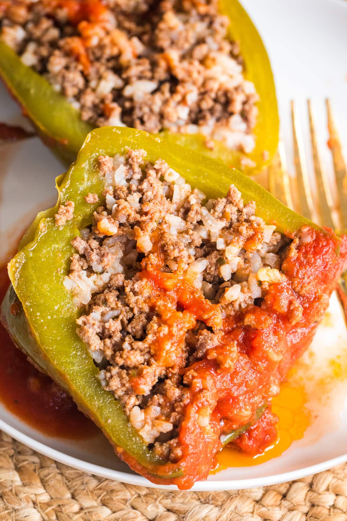 stuffed bell peppers showing the inside of one cut open on a plate.