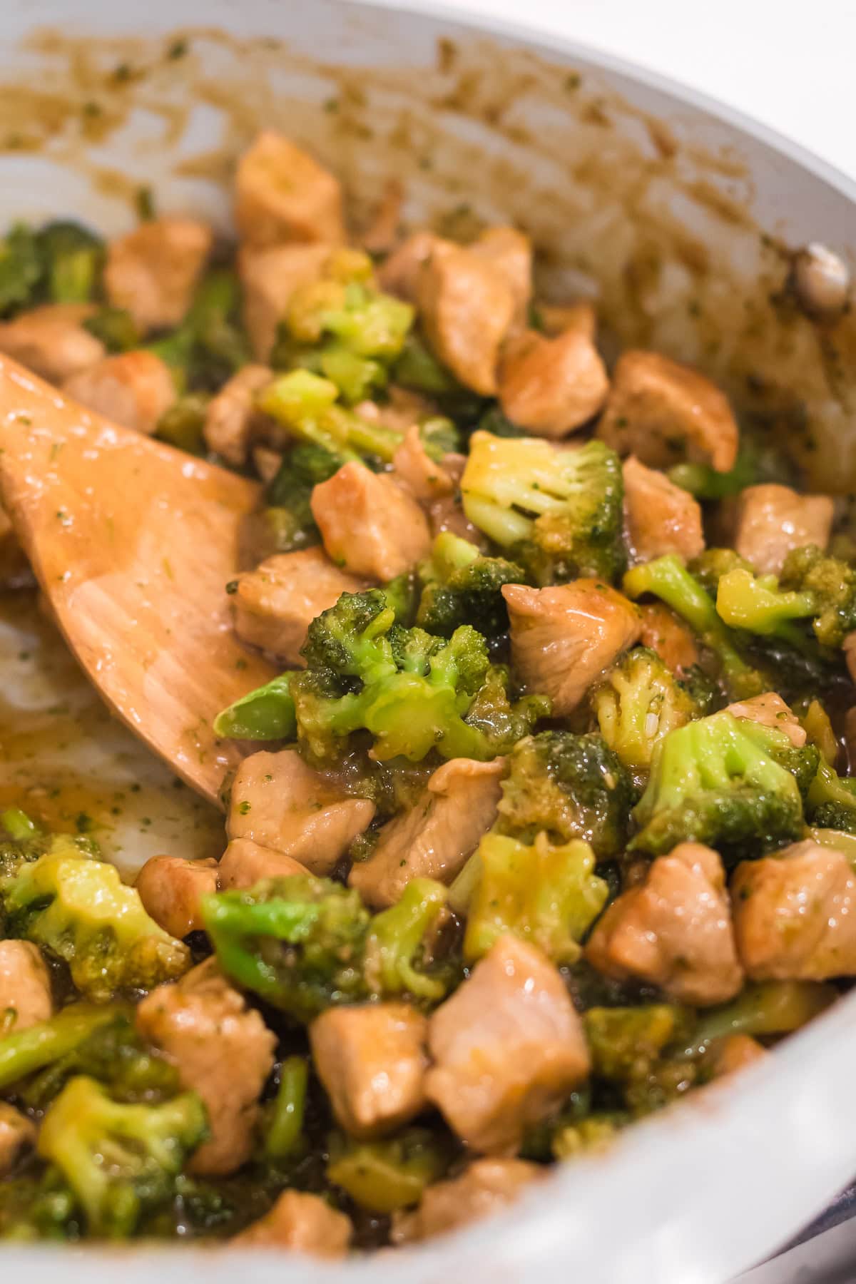 teriyaki pork stir fry with broccoli in a pan with a serving spatula.