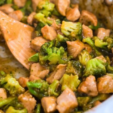 teriyaki pork stir fry with broccoli in a pan with a wooden spatula.