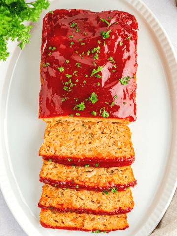 chicken meatloaf half sliced on a white platter.